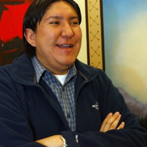 man standing and smiling with his arms crossed