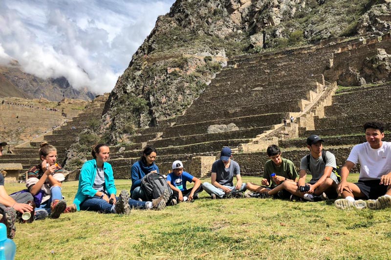 high school students sitting in circle at base of ruins, practicing ways to be more than a tourist
