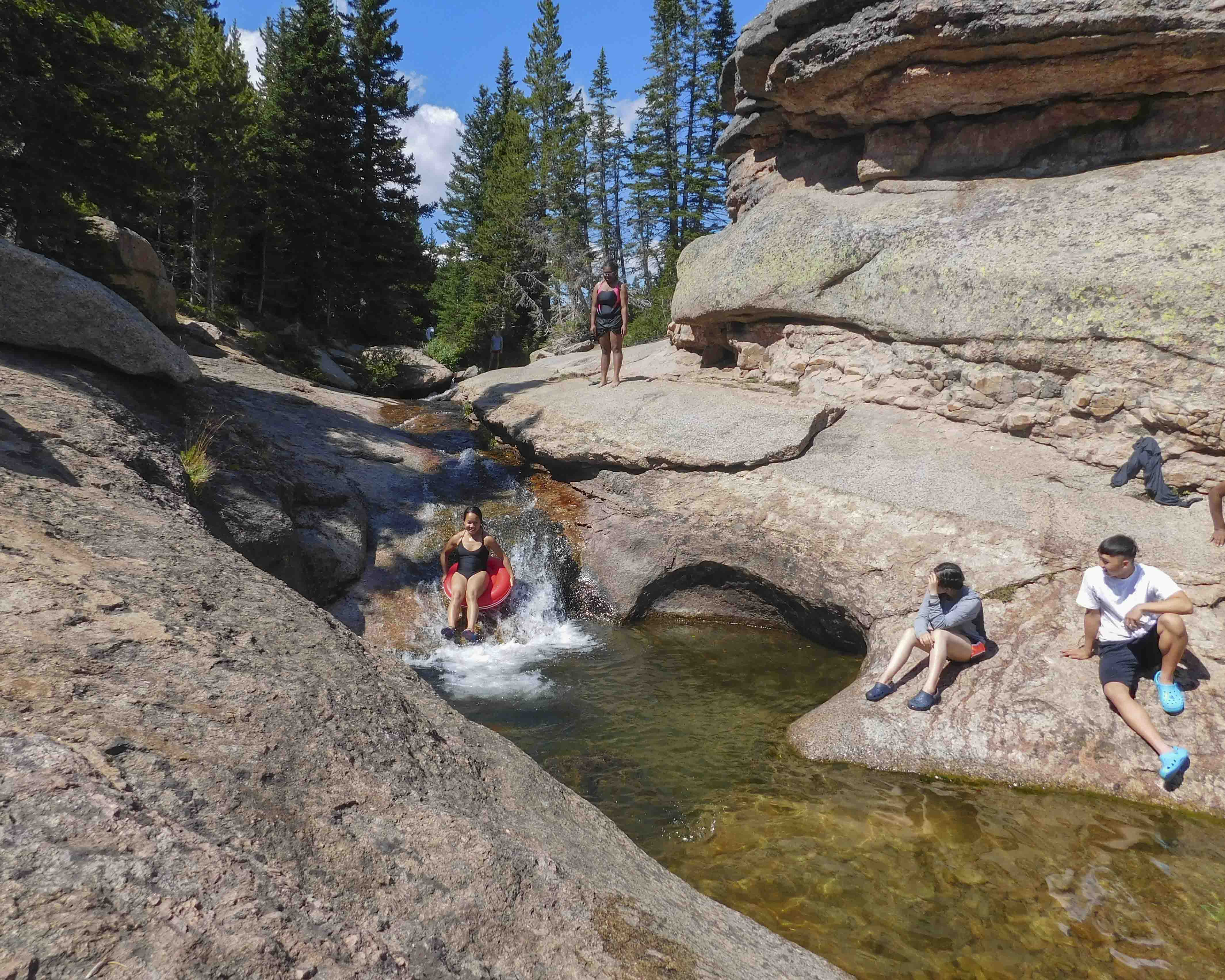Teens slide into natural pool set in rock slabs on community service trips to the Northern Cheyenne
