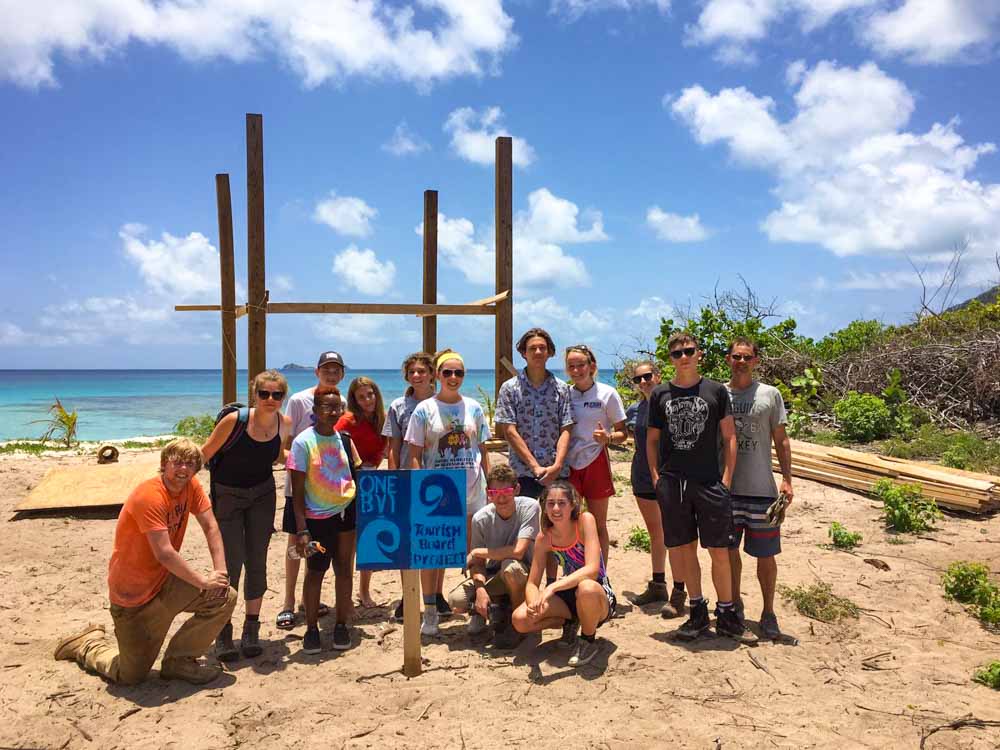 Summer service trip in 2019 poses in front of construction project on beach in British Virgin Islands