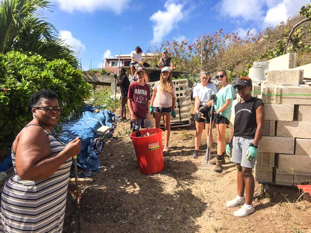 high school volunteers with rakes and and cinder blocks in the British Virgin Islands