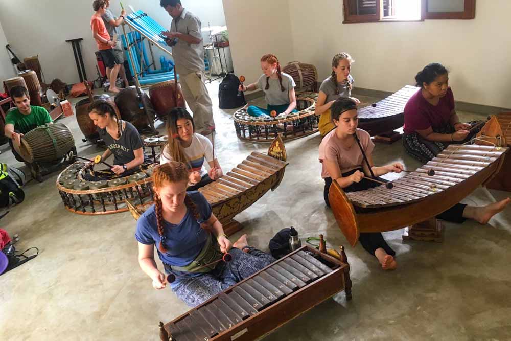 Teens getting cultural immersion as they learn to use Cambodian instruments.