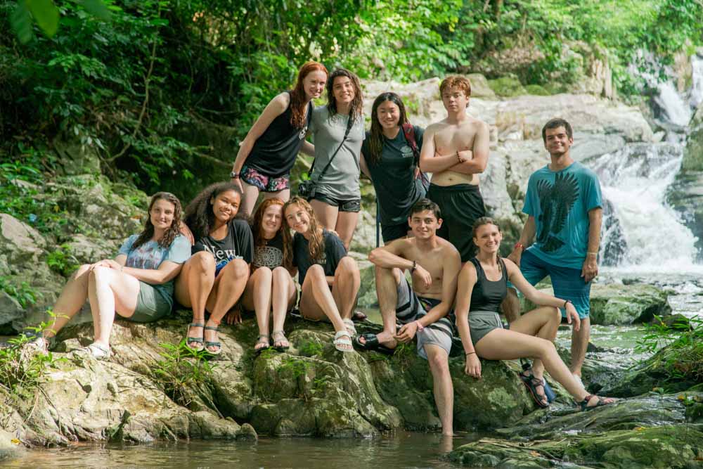 Teens smiling in group photo in the Cambodian jungle.