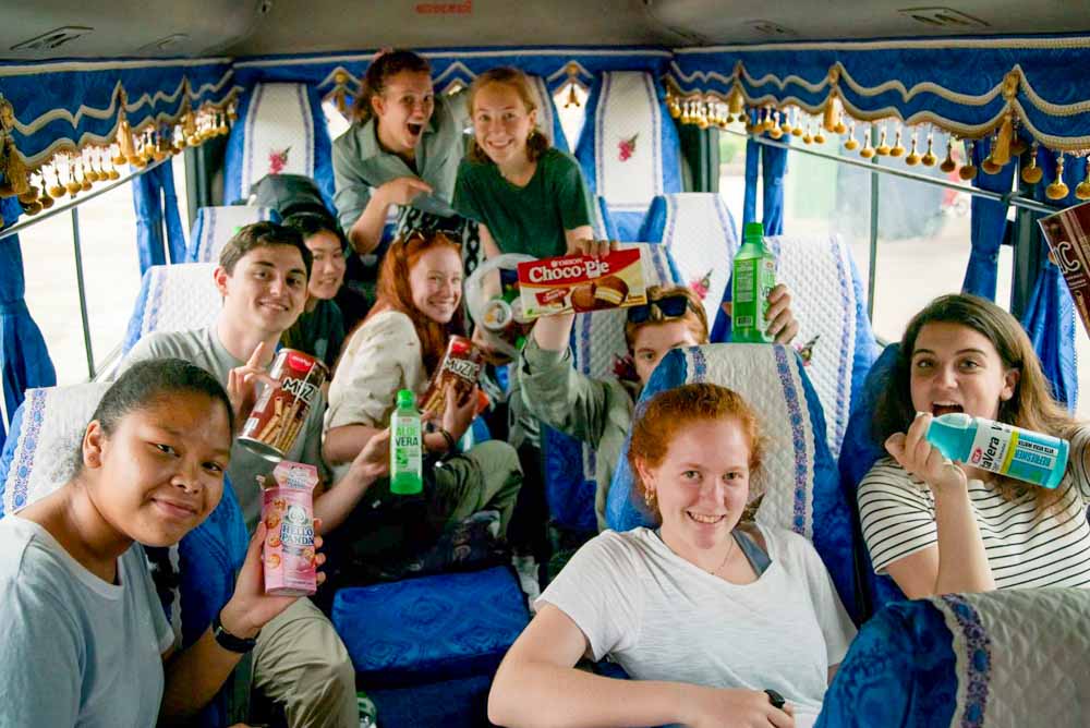 Teen volunteers enjoying Cambodian snacks on a bus ride.