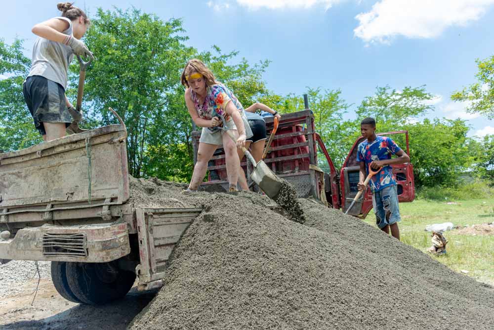 Teens shoveling gravel on a community service project.