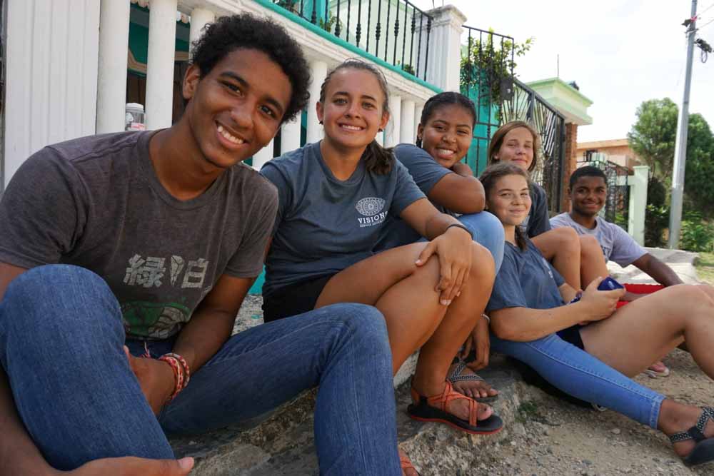 Smiley teens rest on the curb during their teen service trip to the Dominican Republic.