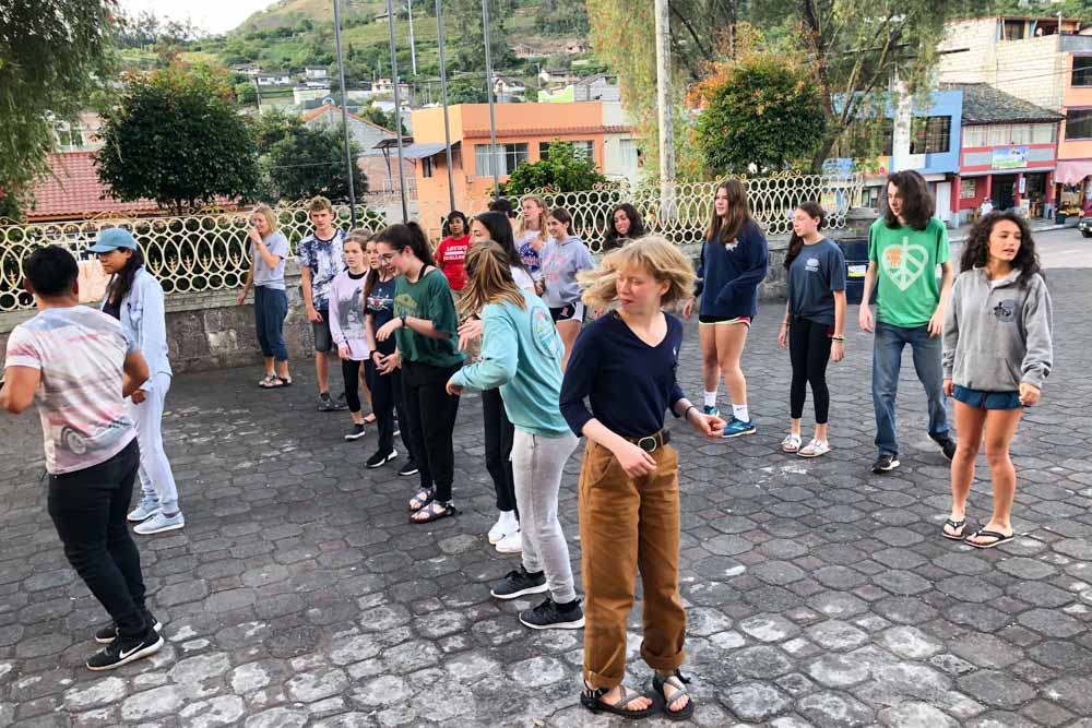 A group of teens practices dancing with community members in Ecuador.