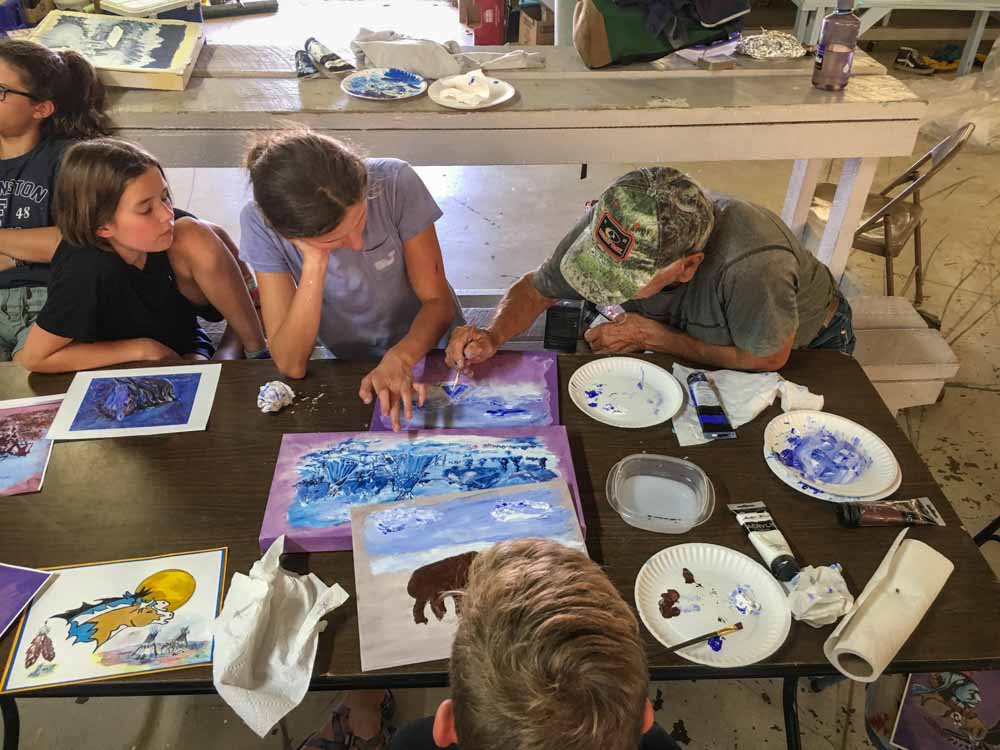 A community member paints with teen volunteers in Montana.