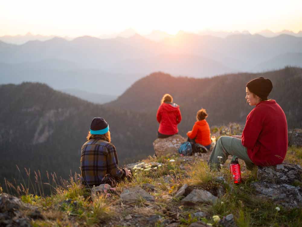 Four teen volunteers enjoy the sunset over the mountains in Montana near the site of their summer service project.