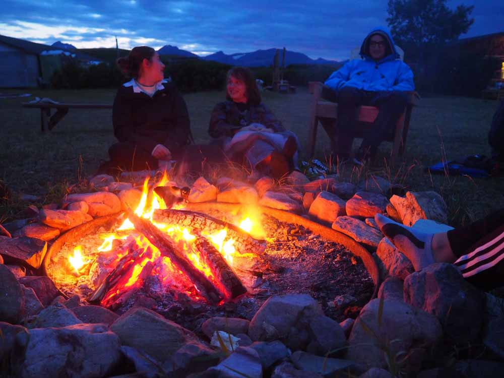Volunteers sit by a campfire after a hard day's work on their teen service projects.