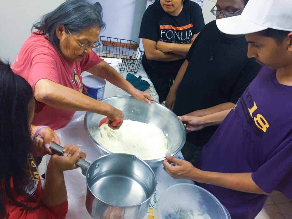 Native woman teaching students how to make frybread.