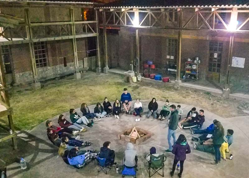 Home away from home for teen volunteers in Peru, teens circle up in courtyard