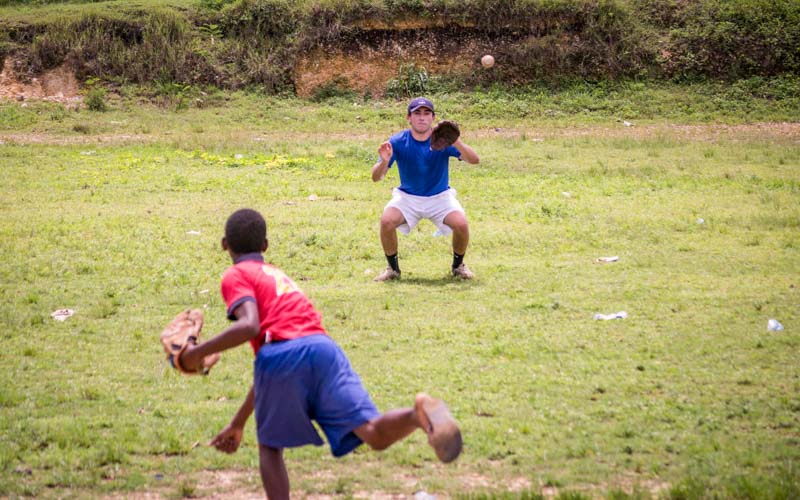 Teens play catch with baseball and mitts in the Dominican Republic