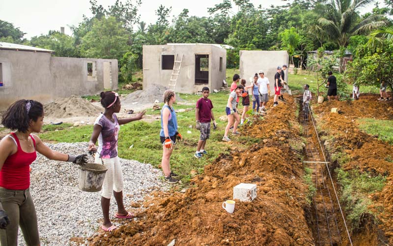 Teen volunteers pass buckets down a trench line in the Dominican Republic