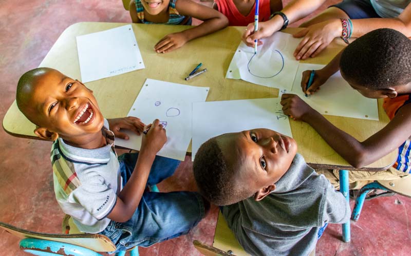 School children in the Dominican Republic draw pictures with international high school volunteers