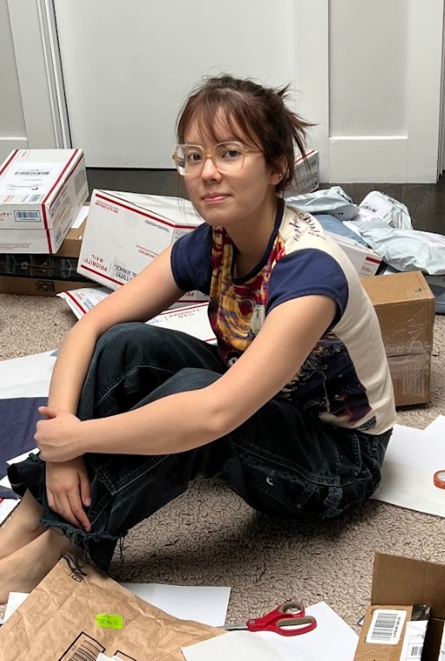 Olivia sits among her fundraising products before shipping them