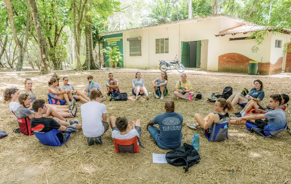 VISIONS-Teen-summer-participants-and-leader-having-a-meeting-Dominican-Republic-Program-scaled