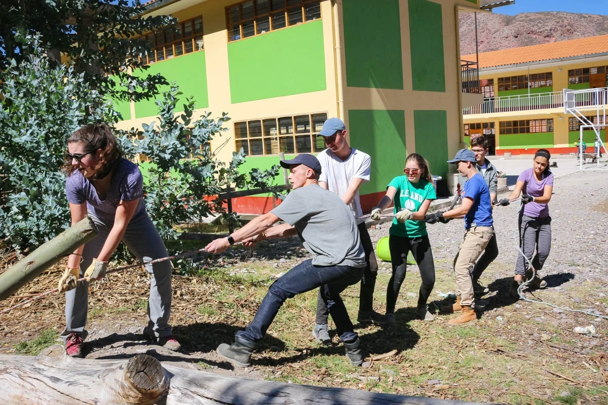 volunteers pulling log at Peru community service