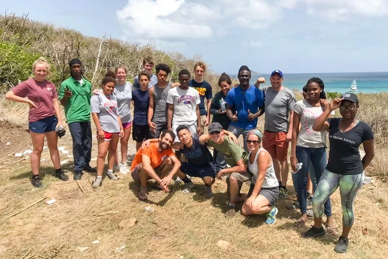 volunteers posing with local community members in the BVI with tools doing trail work