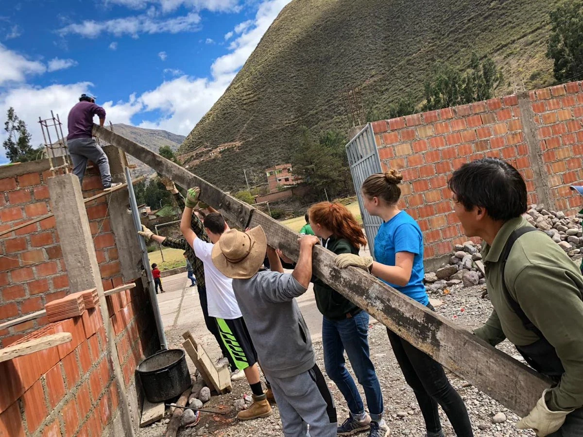Urubamba group of volunteers lifting beam in peru
