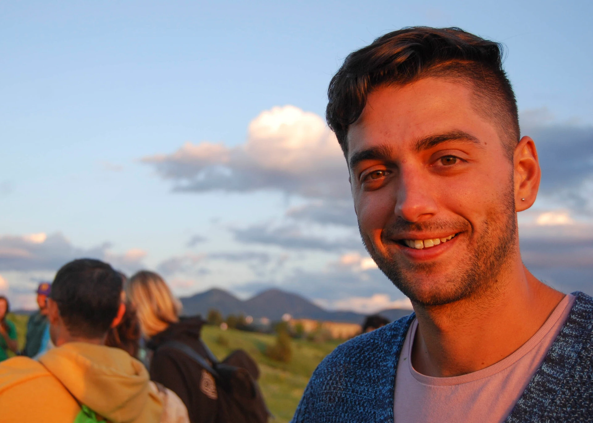 Visions leaders from around the world hike at sunset and man smiles