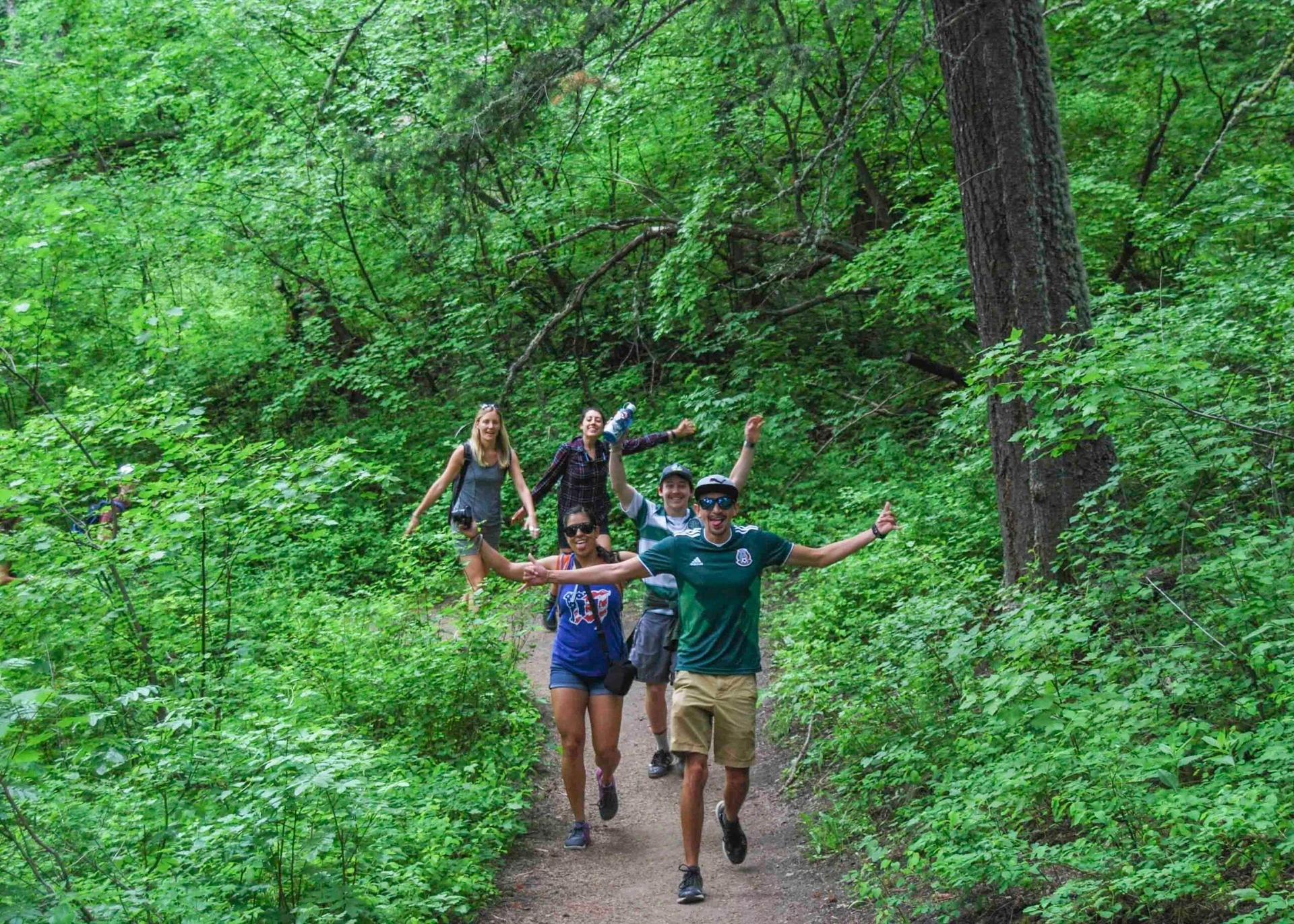 VISIONS leaders from around the world walk in the woods with their hands up in celebration