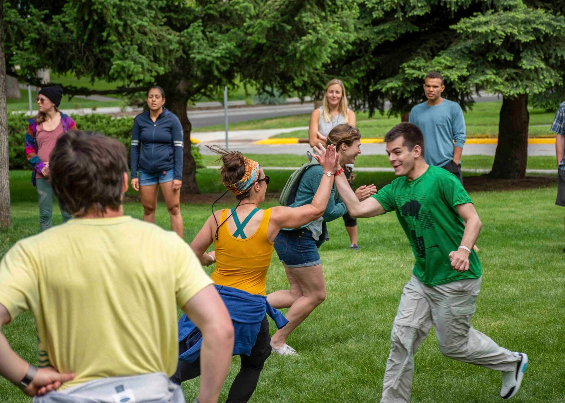 Visions leaders from around the world run around a lawn giving high fives