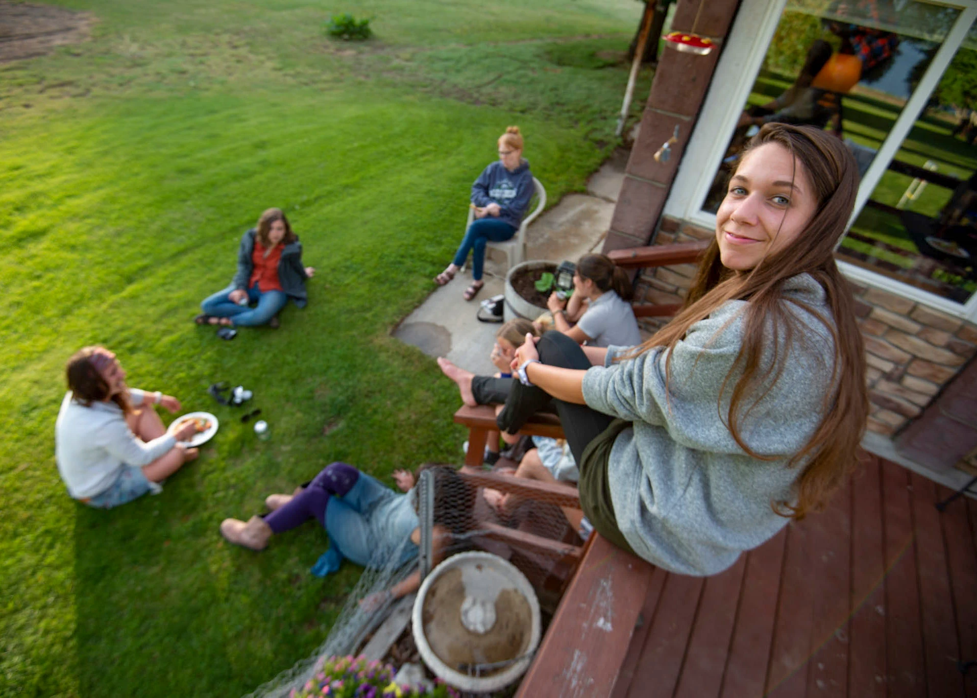 Visions leaders from around the world sit on porch and lawn at BBQ