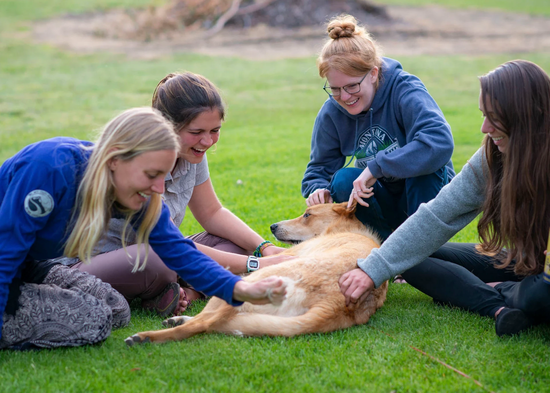 Visions leaders from around the world pet a yellow lab on a lawn