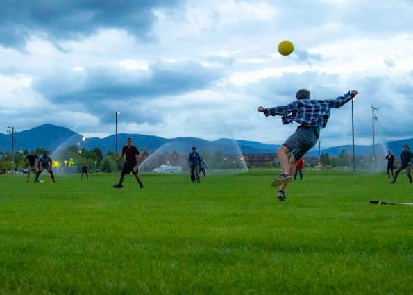 Visions leader kicks ball into the air at dusk