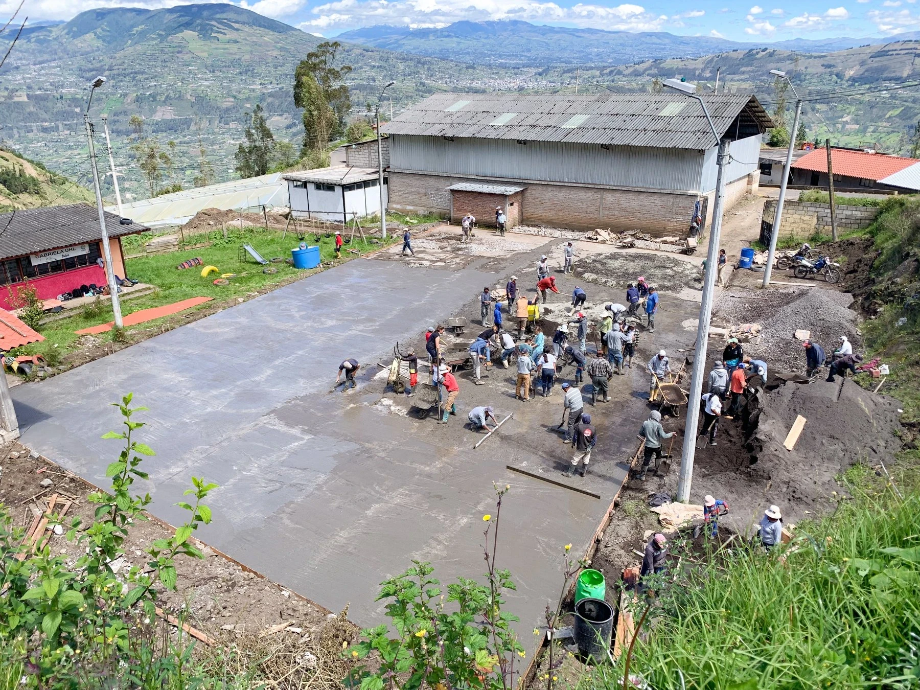 Vantage point view of volunteers restoring soccer pitch for community service in Ecuador