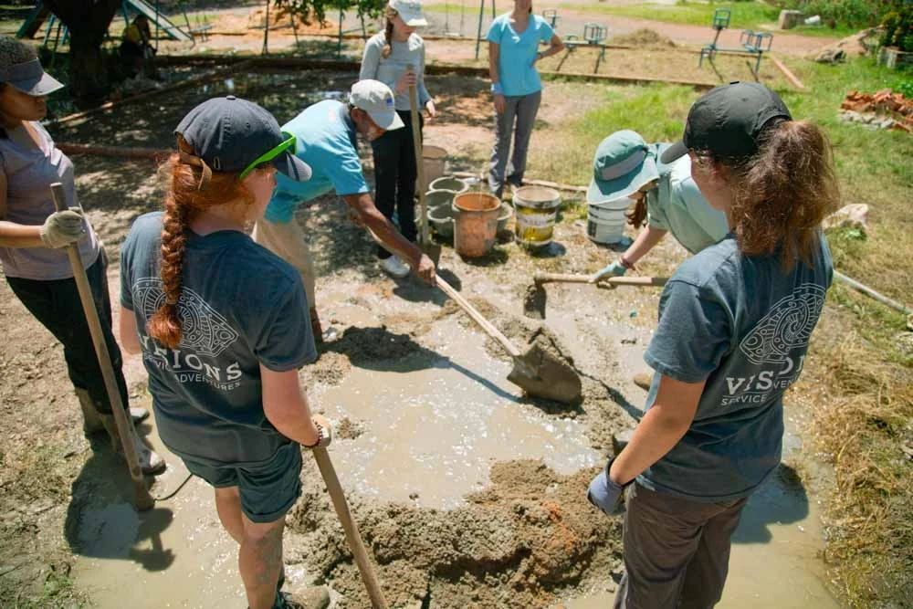 Volunteers help community members dig on their summer service project in Cambodia.