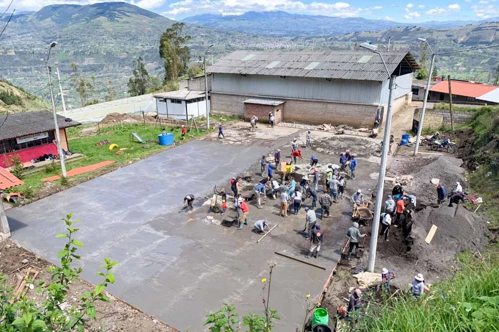 Teen volunteers spread cement on the site of their summer service project in Ecuador.