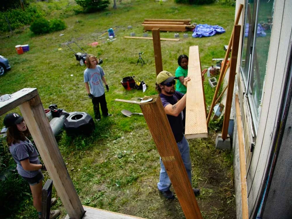 VISIONS leader and volunteers work together building a deck on a summer service project in Montana.