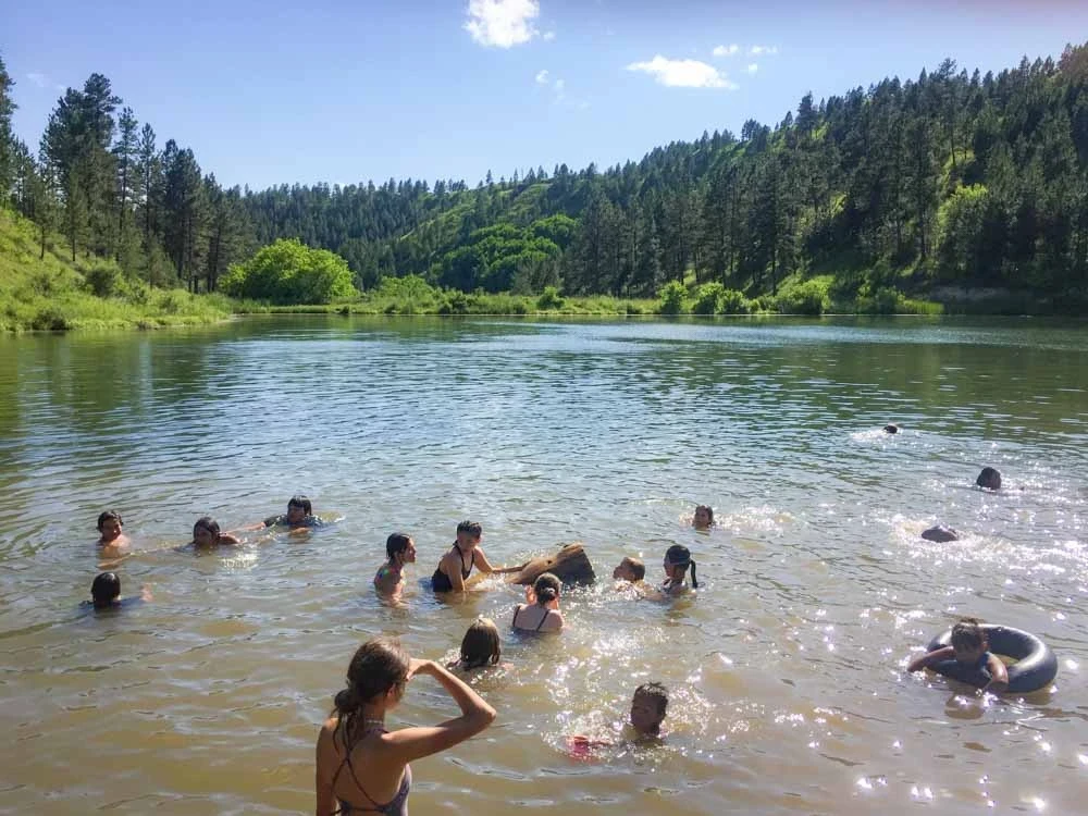 Teen volunteers swim in a river on a day off from their teen service projects in Montana.
