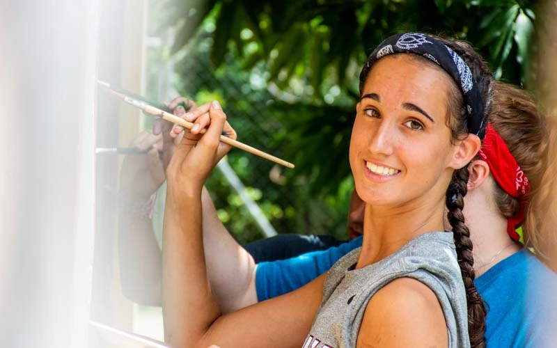Teen volunteer in Dominican Republic paints a mural