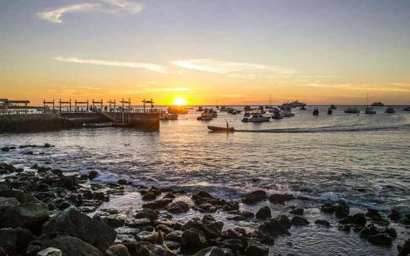 Sunset at a bay full of boats in the Galapagos Islands