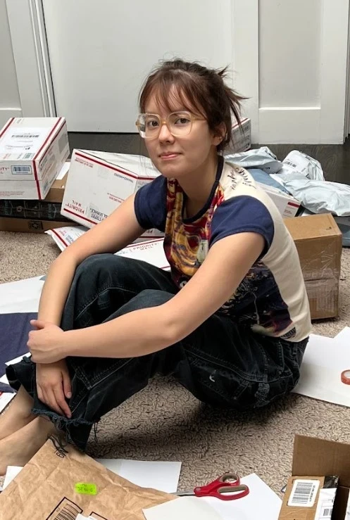 Screenshot_29 Olivia sits among her fundraising products before shipping them