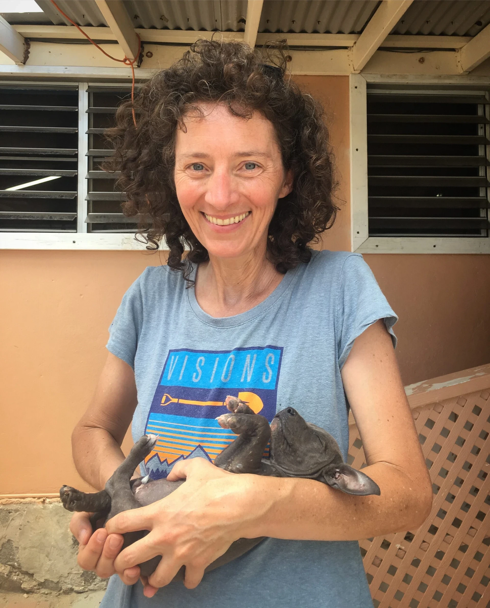 VISIONS Director Katherine Dayton holds a puppy in BVI