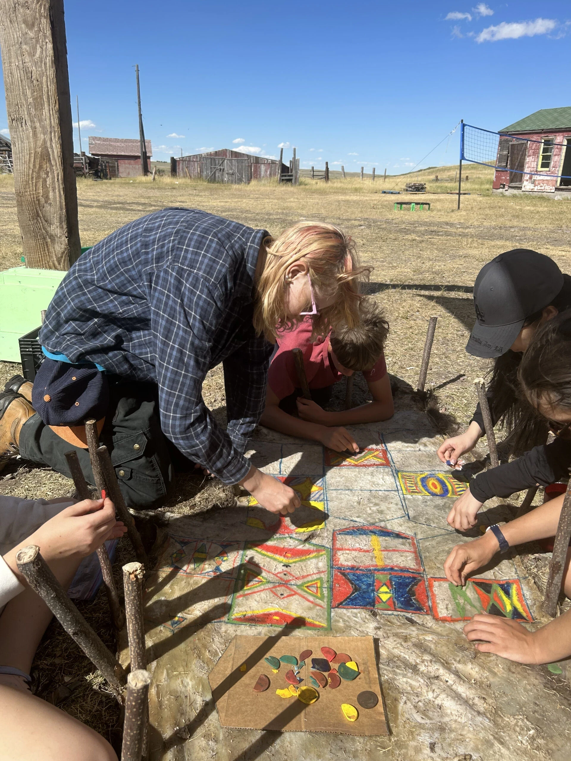 VISIONS teen volunteers decorate a buffalo hide