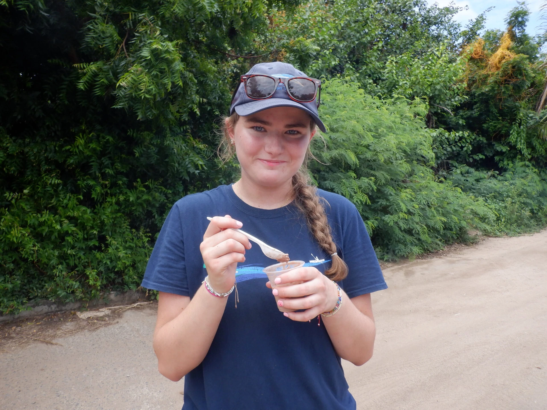 Teen girl holds treat Anni, a VISIONS summer leader alum, with her husband and two children in Austin, TX